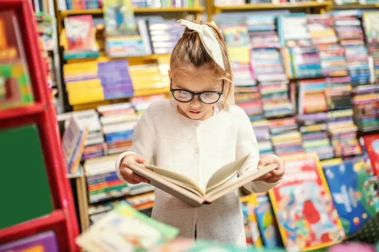 Child reading a book in a bookstore.
