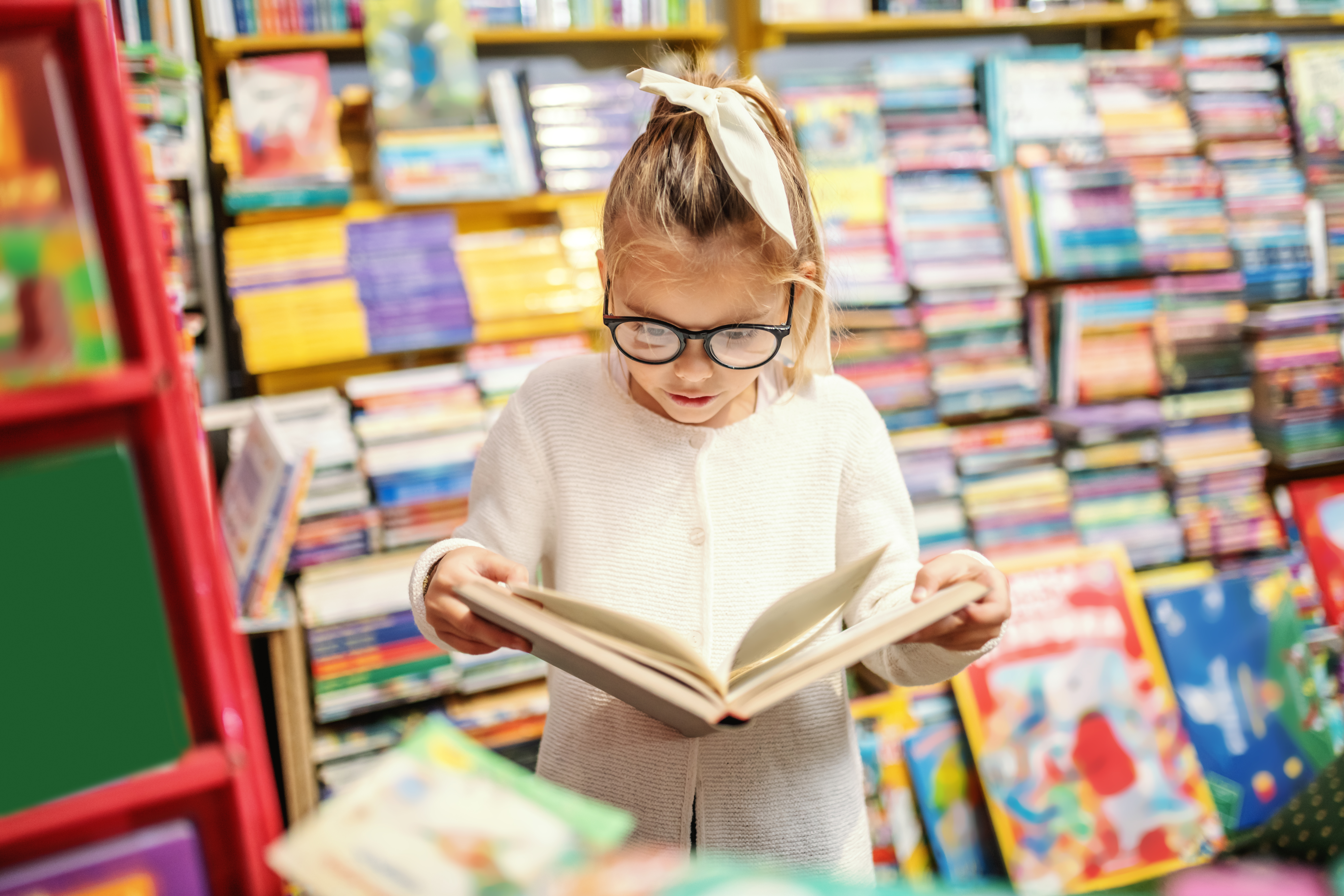 Child reading a book in a bookstore.