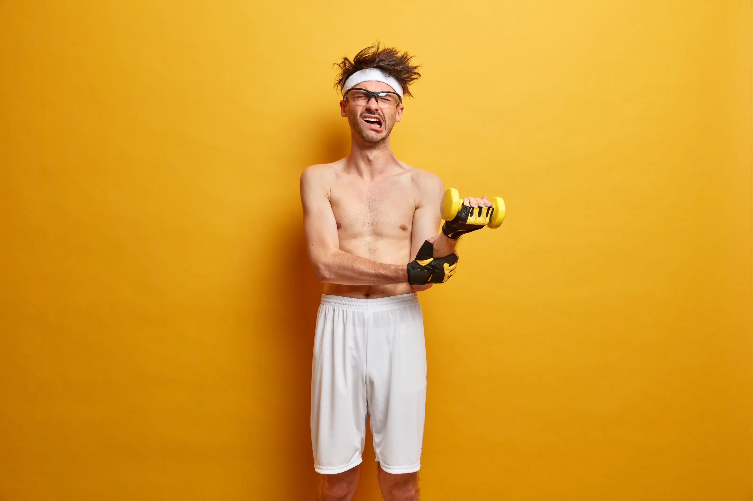 Man lifting small dumbbell with funny expression.