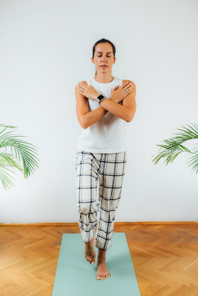 Woman balancing on one foot with closed eyes.