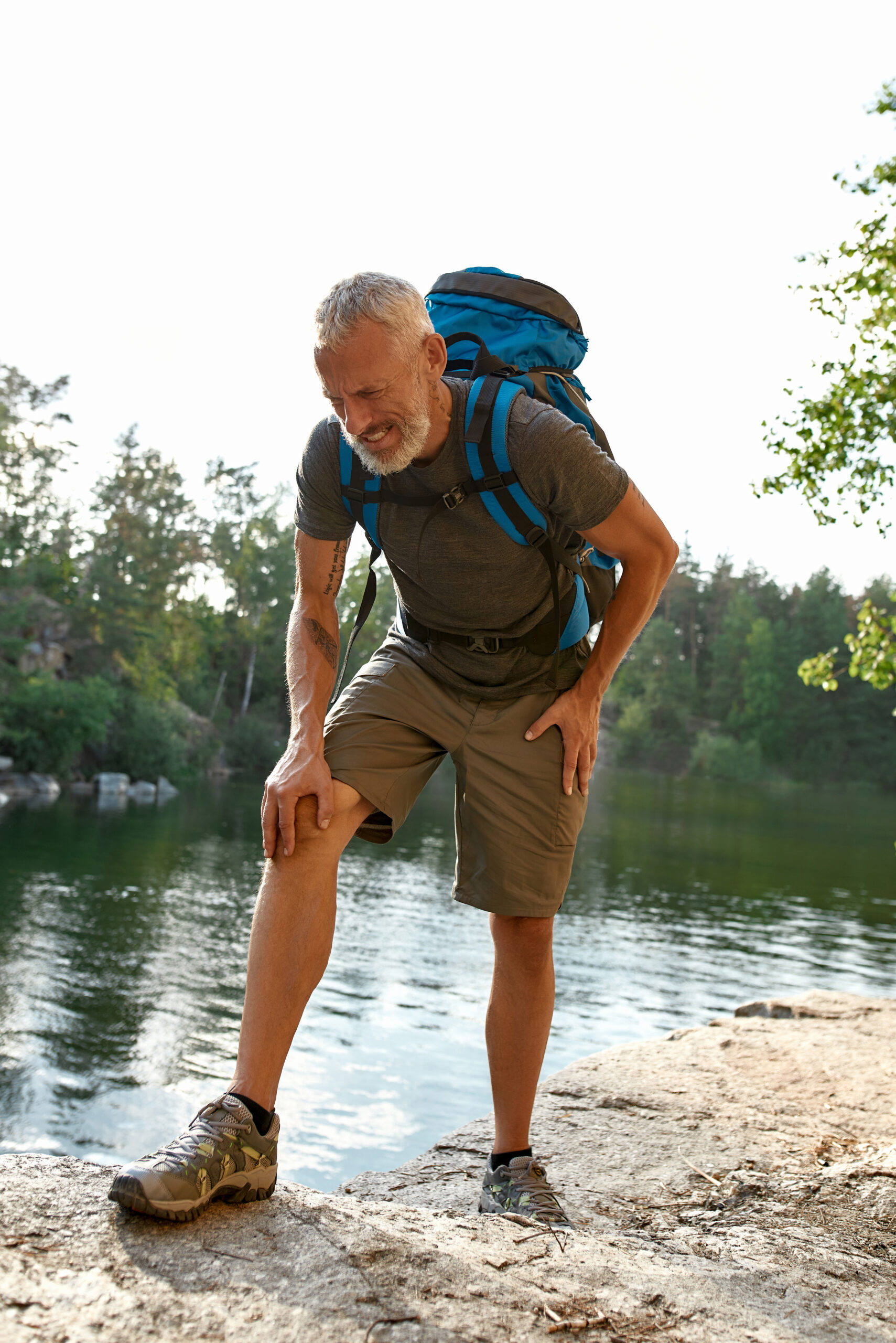 Hiker resting by a lake in the forest.