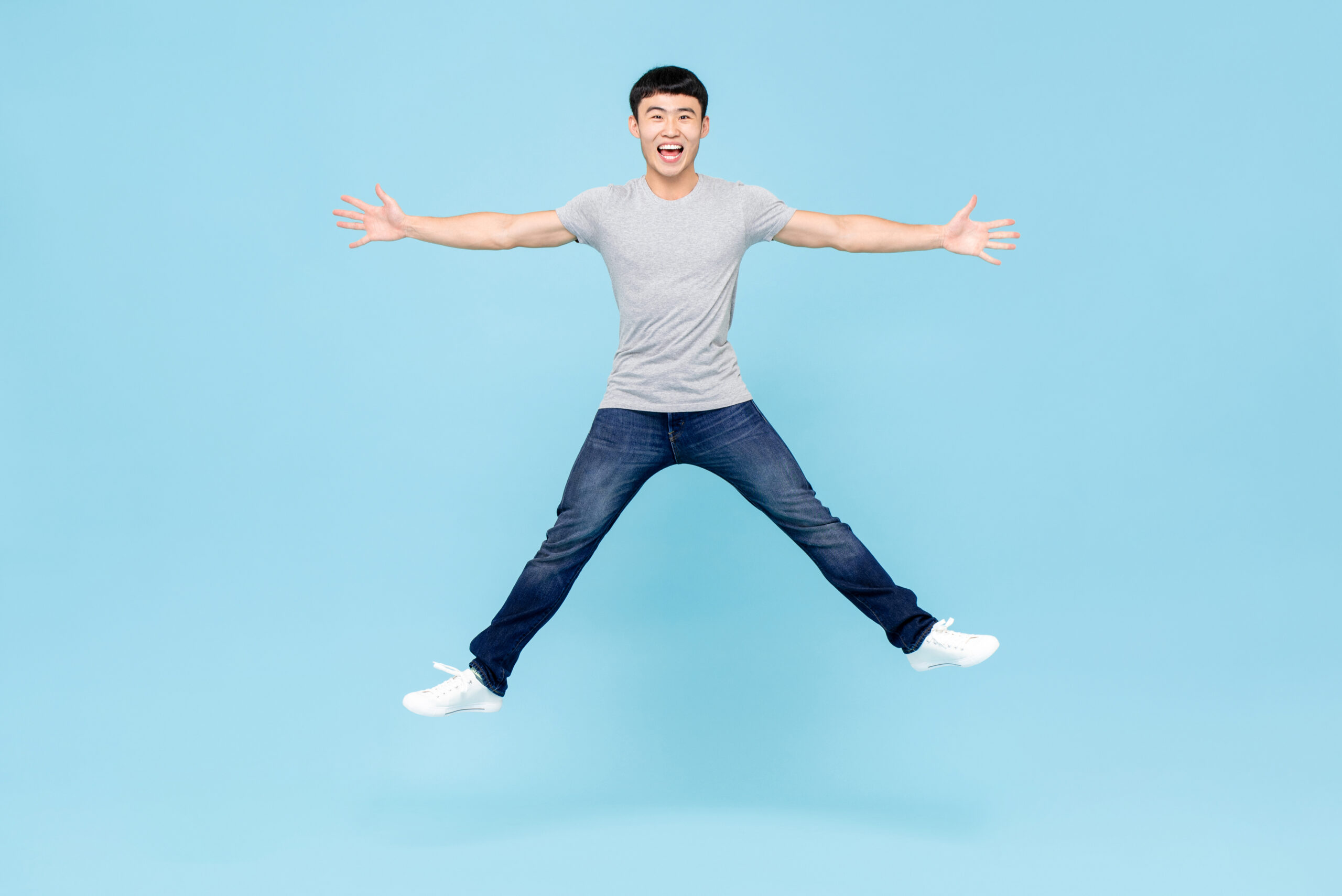 Man jumping joyfully against blue background