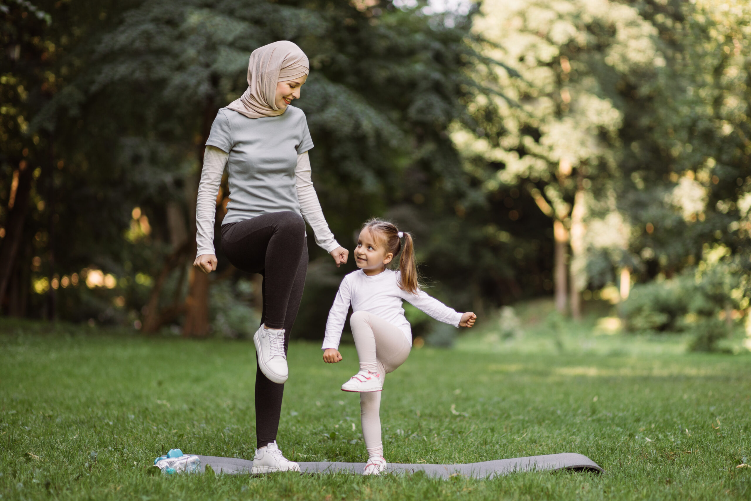 Mother and daughter exercising in a park