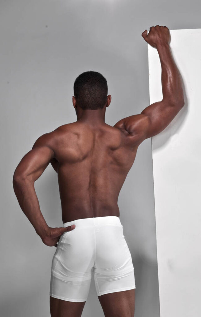 Man in athletic shorts showing muscular back.