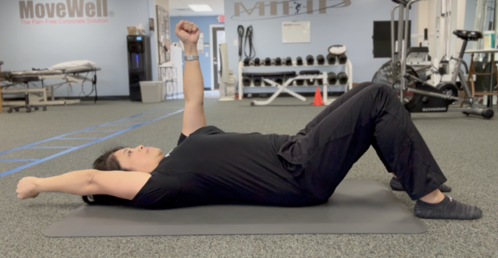 Person performing back exercise in gym setting.
