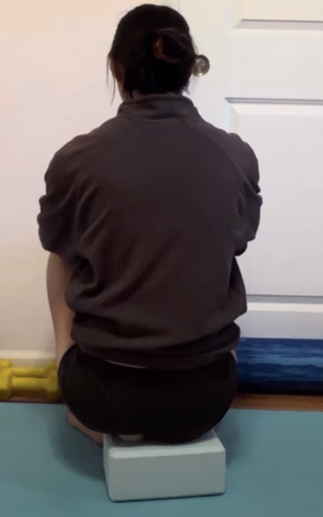 Person sitting on yoga block in meditation