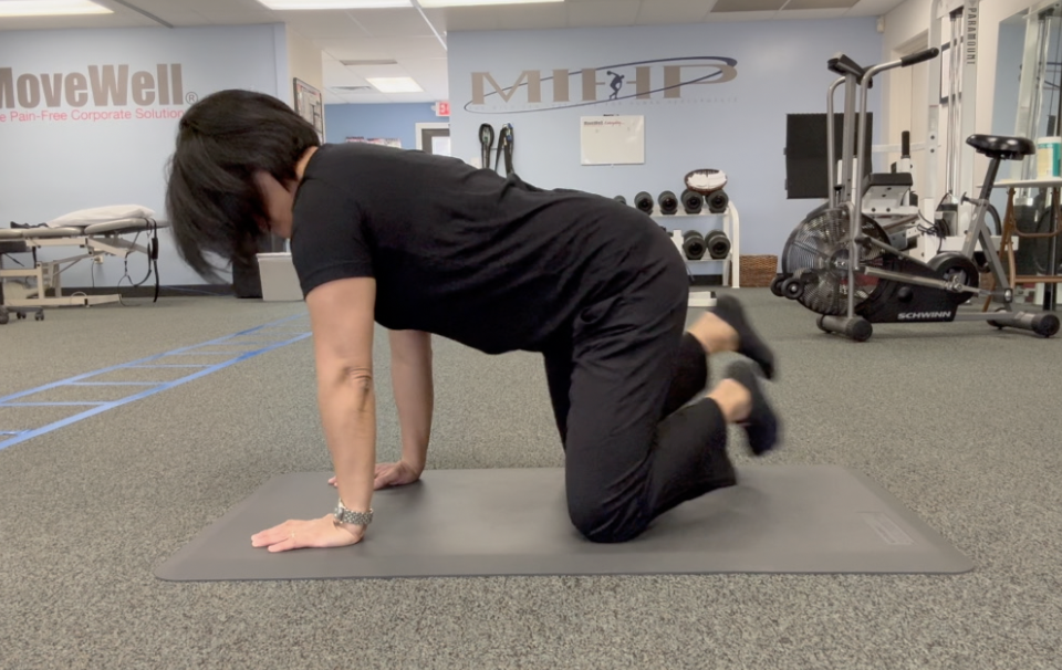 Person exercising on mat in fitness center.